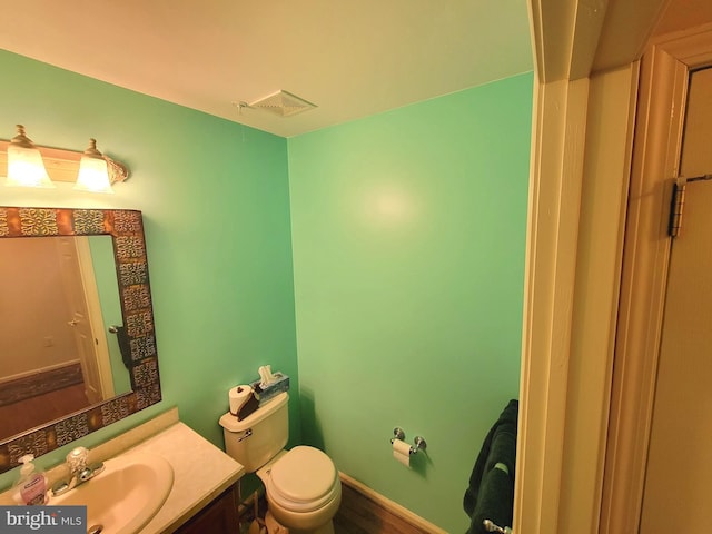 bathroom featuring toilet, baseboards, visible vents, and vanity