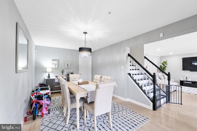 dining space with a notable chandelier and light hardwood / wood-style flooring