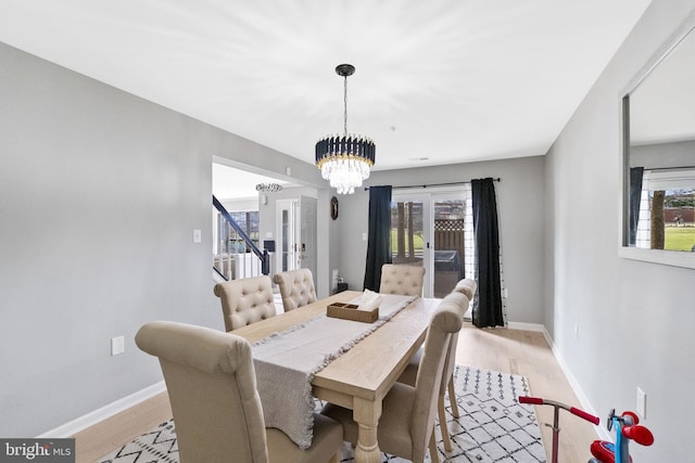 dining space featuring light hardwood / wood-style floors and an inviting chandelier