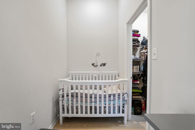 bedroom featuring a crib and hardwood / wood-style flooring