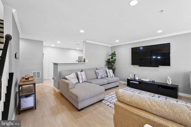 living room featuring light hardwood / wood-style flooring and ornamental molding