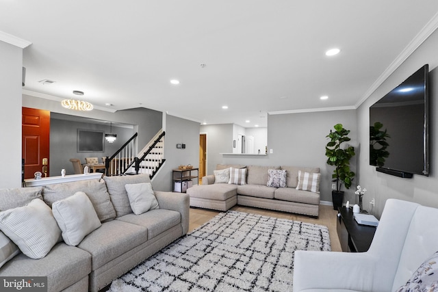 living room with crown molding, light hardwood / wood-style flooring, and an inviting chandelier