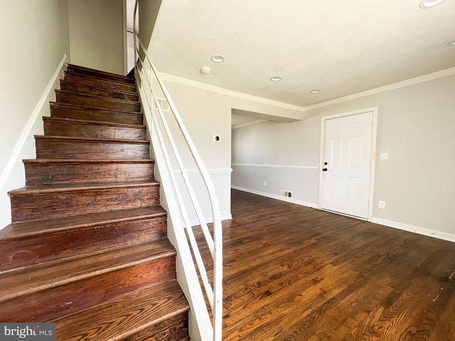 staircase with wood-type flooring and ornamental molding