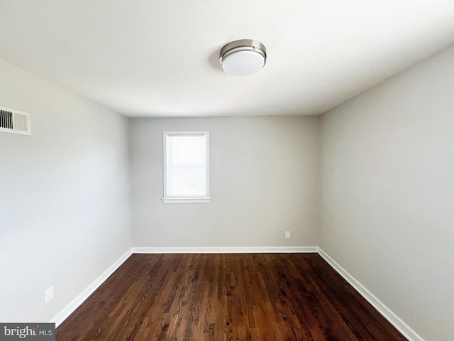 spare room with dark wood-type flooring