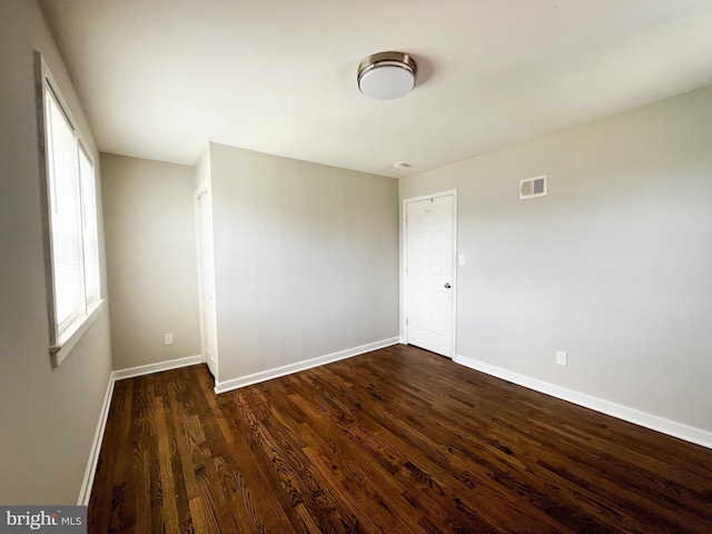 unfurnished room featuring dark hardwood / wood-style flooring and a healthy amount of sunlight