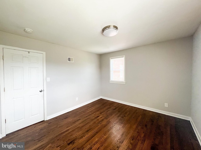 unfurnished room with dark hardwood / wood-style floors