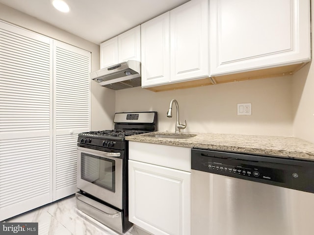 kitchen with white cabinets, light stone counters, sink, and appliances with stainless steel finishes