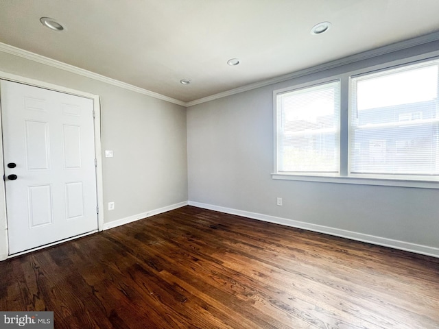 empty room featuring ornamental molding, a healthy amount of sunlight, and hardwood / wood-style flooring