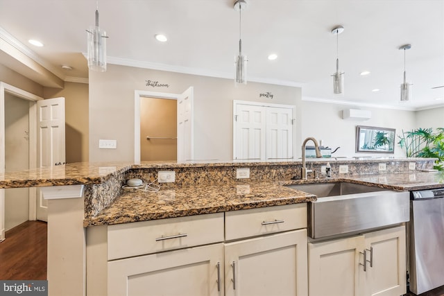 kitchen featuring a wall unit AC, a sink, hanging light fixtures, ornamental molding, and dark stone countertops