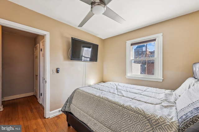 bedroom featuring a ceiling fan, baseboards, and wood finished floors