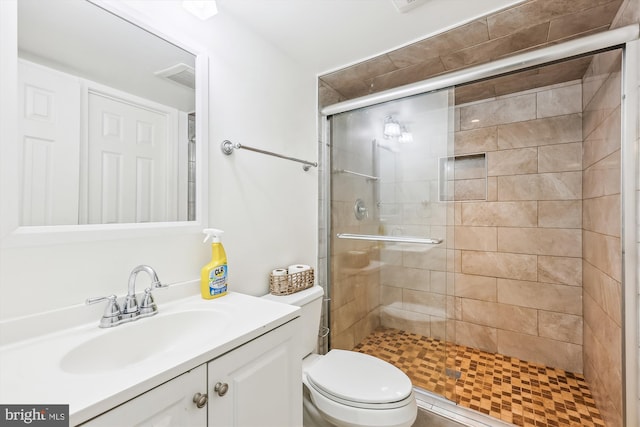 bathroom featuring visible vents, a stall shower, vanity, and toilet