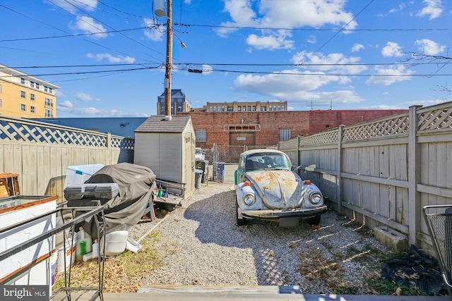 view of yard featuring a storage unit, an outdoor structure, and a fenced backyard