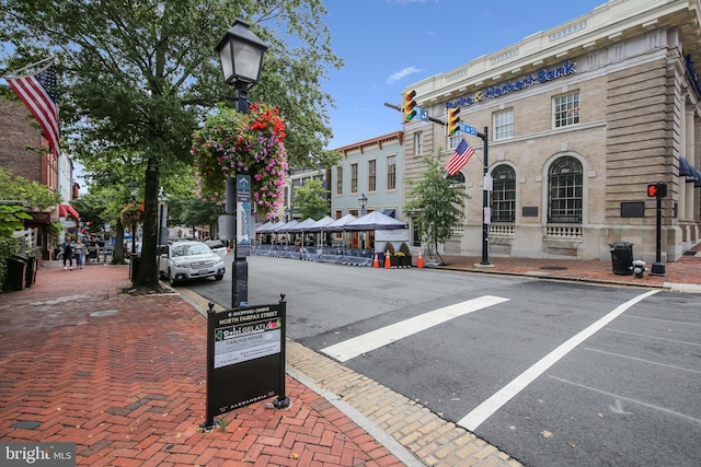 view of road with sidewalks, street lights, and curbs