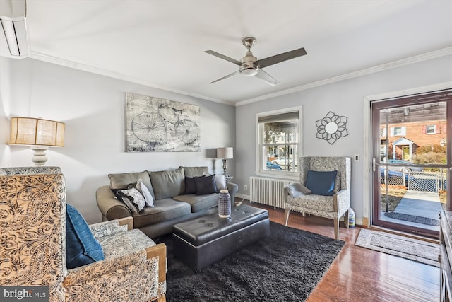 living area with ornamental molding, dark wood-style flooring, plenty of natural light, and radiator heating unit