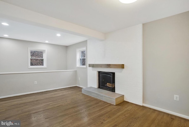 unfurnished living room with dark hardwood / wood-style flooring and a fireplace