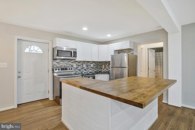 kitchen featuring butcher block counters, white cabinets, and appliances with stainless steel finishes