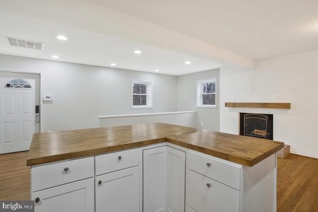 kitchen featuring white cabinets, wood counters, and light hardwood / wood-style flooring