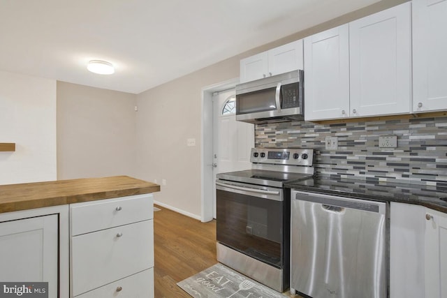 kitchen featuring wooden counters, backsplash, light hardwood / wood-style floors, white cabinets, and appliances with stainless steel finishes