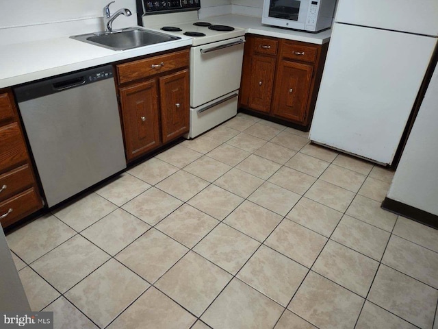 kitchen with sink, light tile patterned flooring, and white appliances