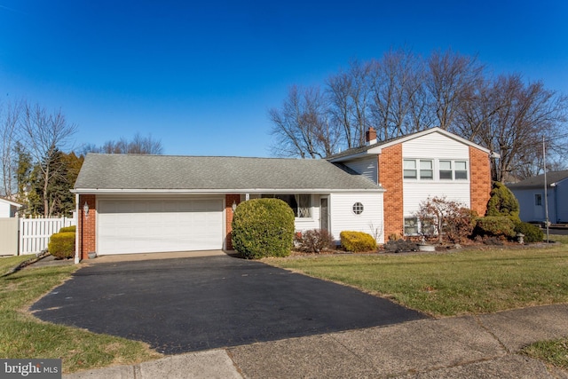 split level home with a front yard and a garage