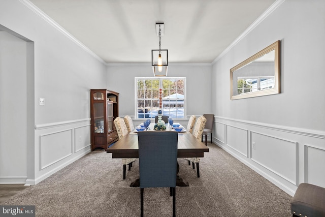 carpeted dining room with ornamental molding