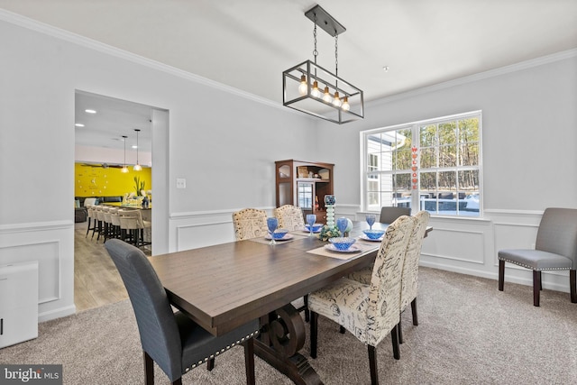 dining area featuring light colored carpet and crown molding