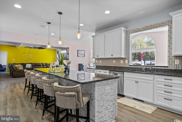 kitchen featuring dishwasher, white cabinetry, sink, and tasteful backsplash