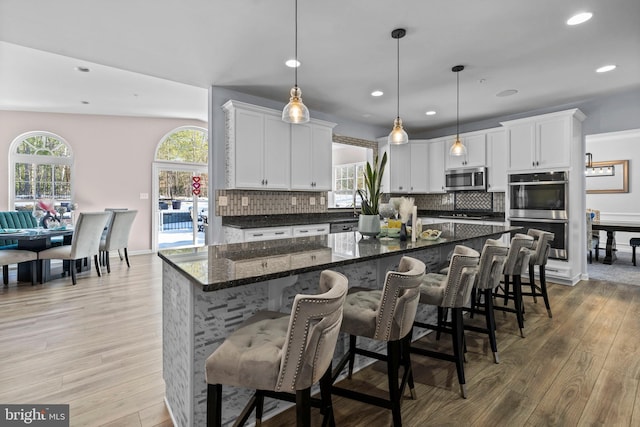 kitchen with white cabinetry, plenty of natural light, hanging light fixtures, and appliances with stainless steel finishes