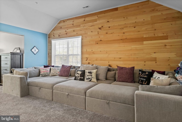 living room with wood walls, carpet floors, and lofted ceiling