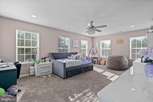 bedroom with multiple windows, ceiling fan, and carpet