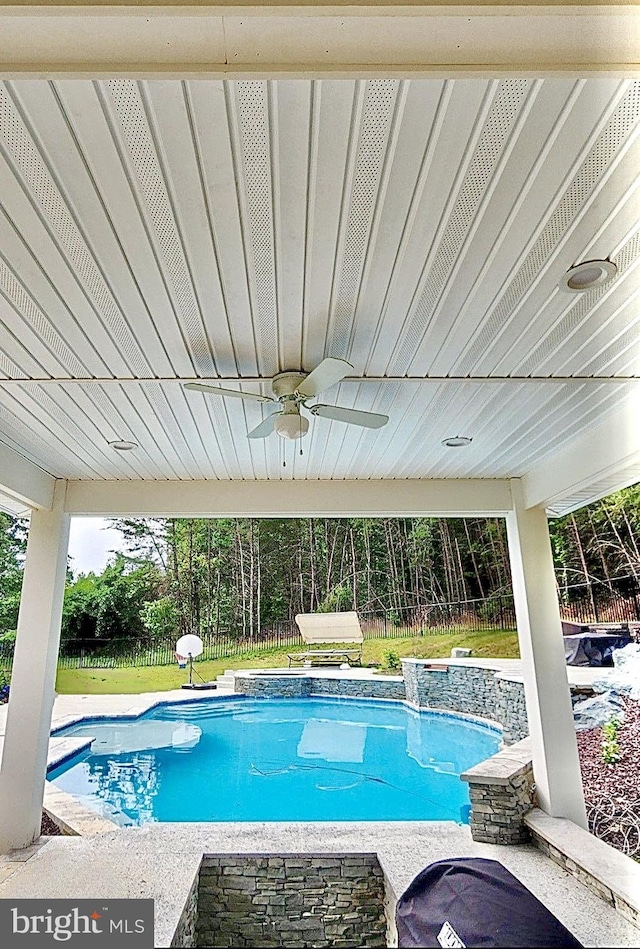 view of pool featuring a lawn and ceiling fan