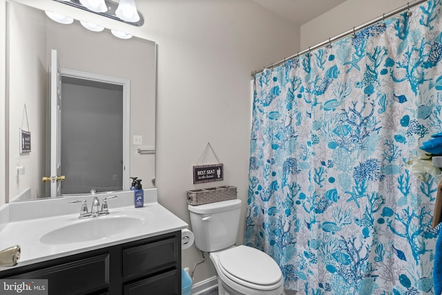 bathroom with vanity, curtained shower, and toilet