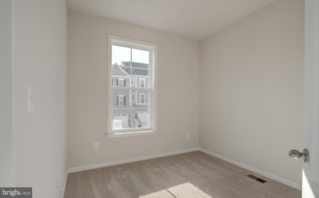 spare room featuring light colored carpet