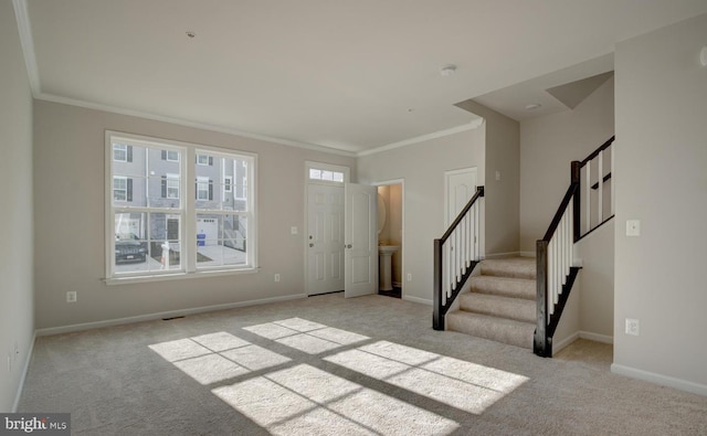 foyer entrance with light colored carpet and ornamental molding