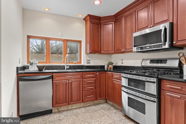 kitchen with dark stone countertops, sink, and appliances with stainless steel finishes