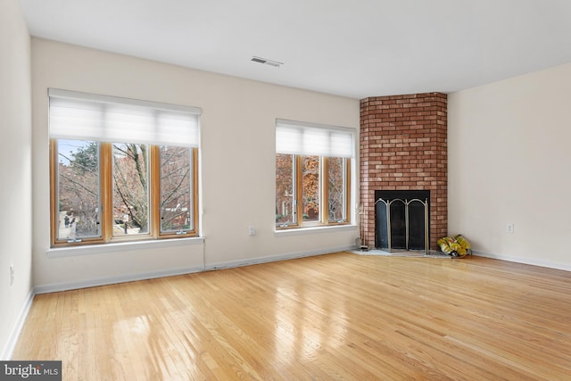 unfurnished living room with light wood-type flooring and a fireplace