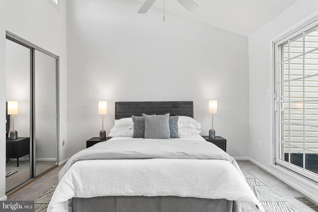 carpeted bedroom with ceiling fan, a closet, vaulted ceiling, and multiple windows