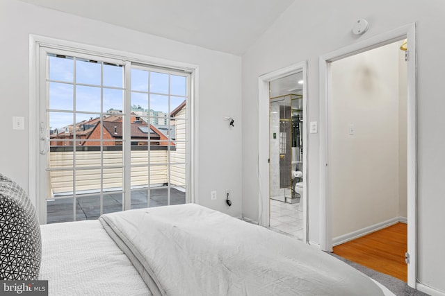 bedroom featuring access to outside, lofted ceiling, and hardwood / wood-style flooring