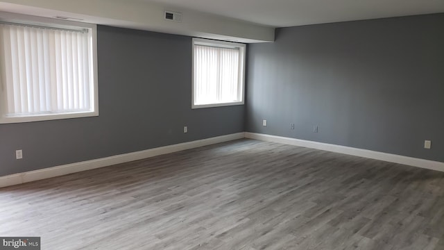 unfurnished room with visible vents, baseboards, and wood finished floors