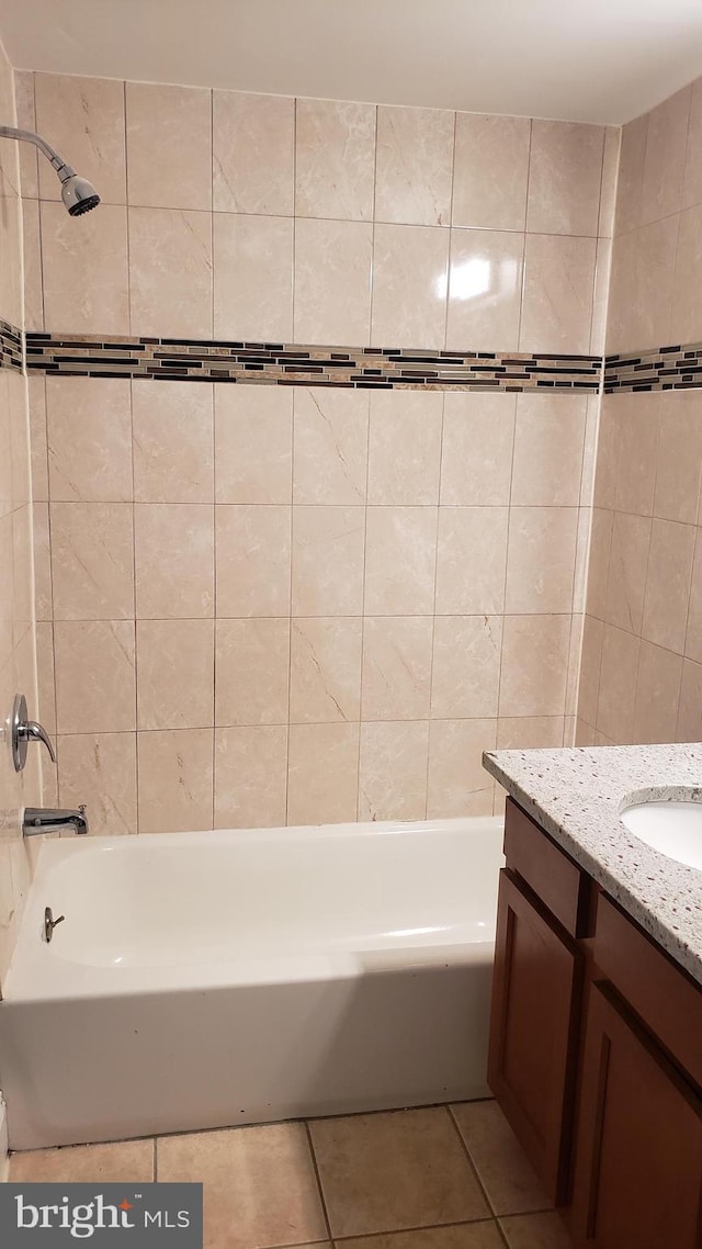 bathroom with tile patterned flooring, vanity, and tiled shower / bath