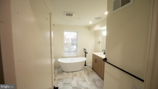 bathroom featuring a bathing tub, vanity, and wood-type flooring