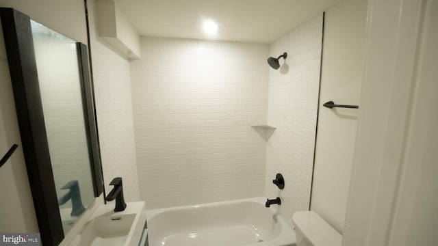 bathroom featuring toilet and tiled shower / bath