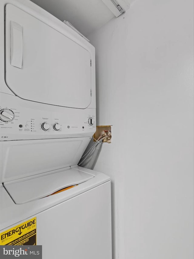 washroom featuring stacked washer and clothes dryer