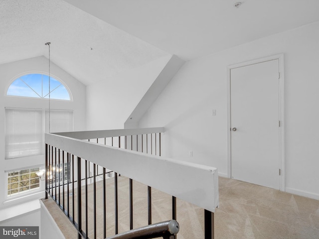 hall with light carpet and vaulted ceiling