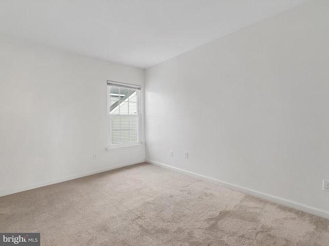 spare room featuring light colored carpet