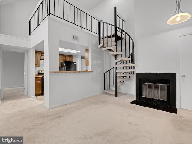 unfurnished living room with light carpet and a high ceiling