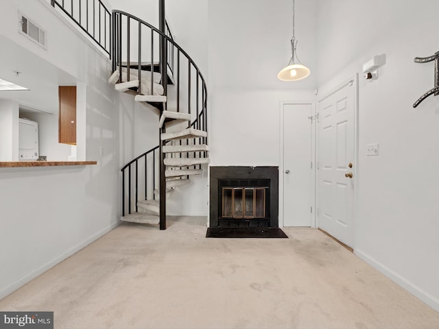 carpeted foyer entrance with a towering ceiling