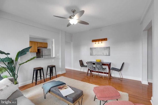 living room with light hardwood / wood-style floors and ceiling fan