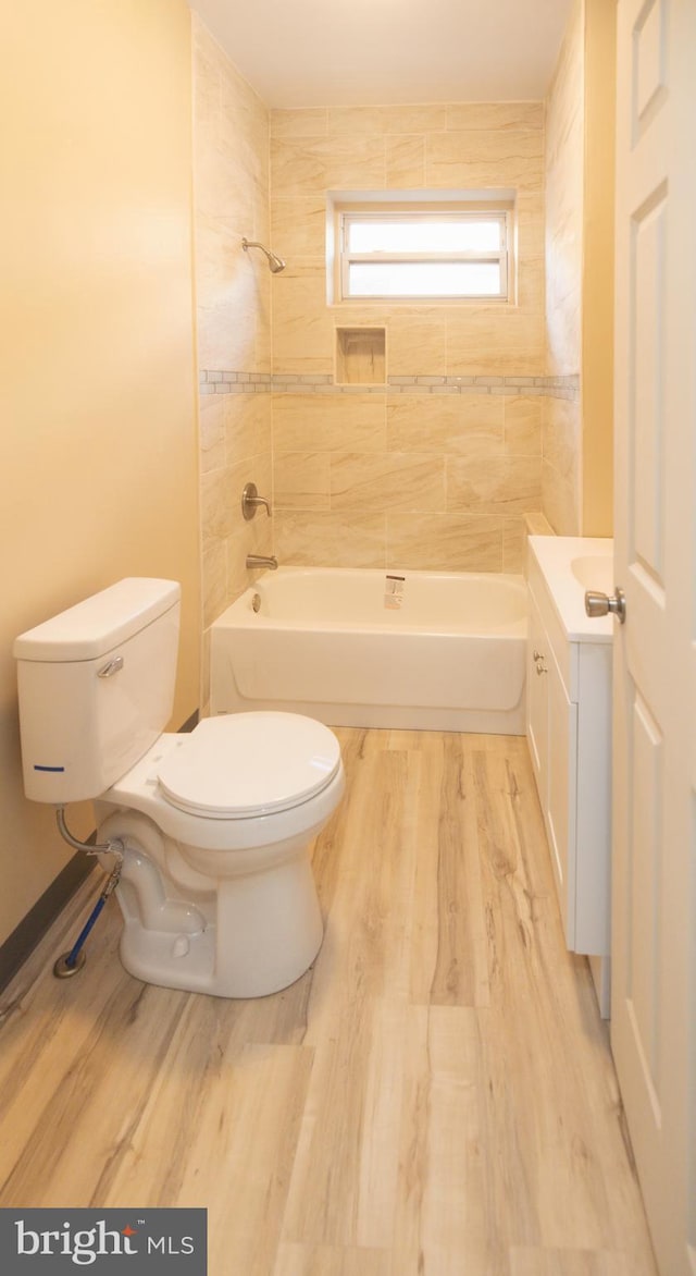 bathroom featuring shower / washtub combination, toilet, vanity, and wood finished floors