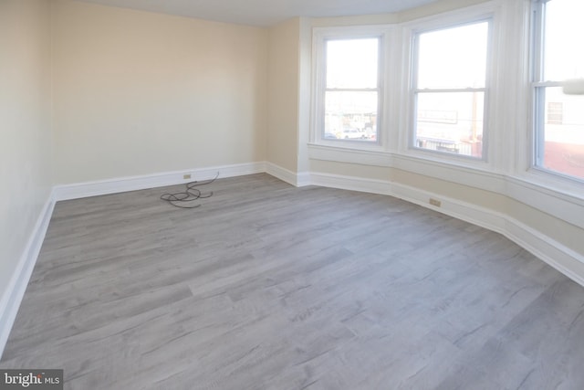 empty room with baseboards and wood finished floors